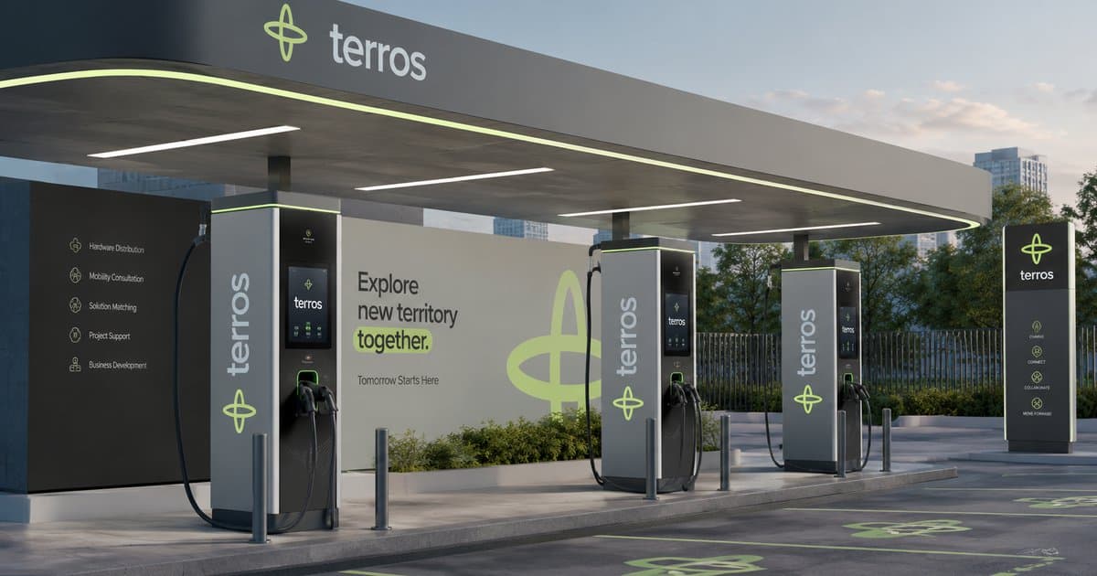 Concept render of a Terros forecourt with four DC chargers under a canopy, in the evening
